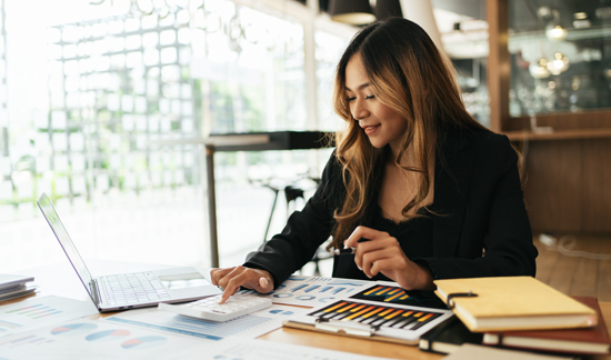businesswoman analyzing charts and graphs at desk with laptop documents and stationery in modern office setting 3 strategies for growth