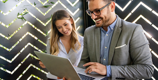 man and woman smiling and engaging with laptop in modern office setting collaborative work 5 key strategies for success